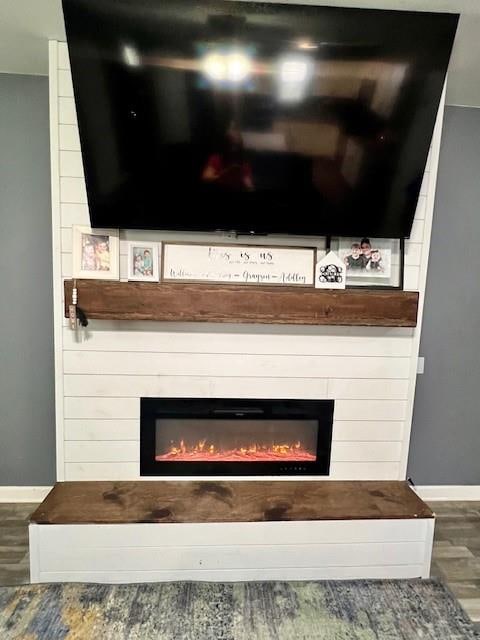 room details featuring wood-type flooring and a large fireplace