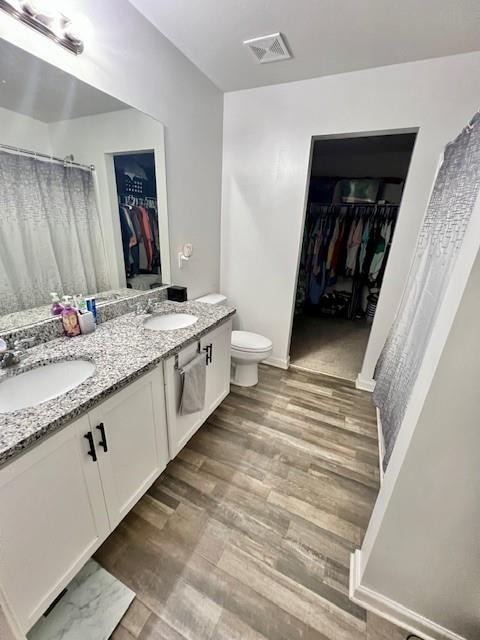 bathroom featuring wood-type flooring, vanity, and toilet