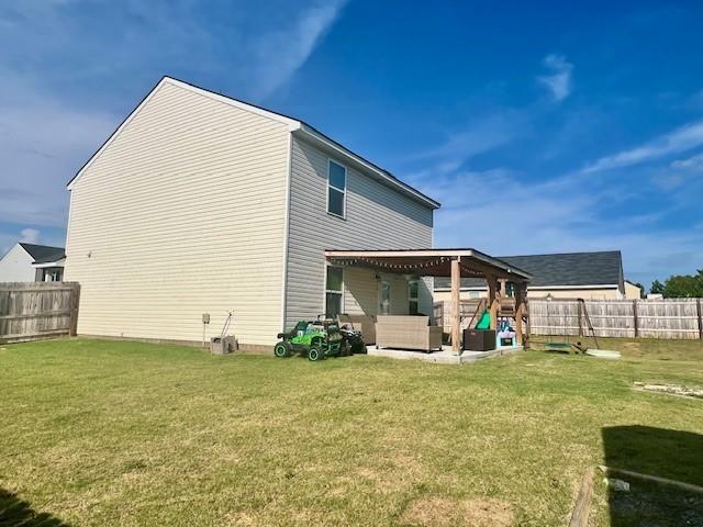 rear view of property with a yard and a patio