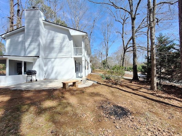 view of side of property with a patio and a chimney