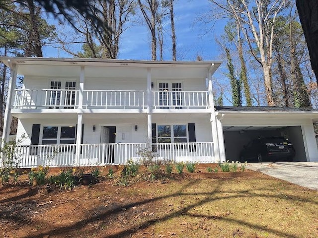 view of front facade featuring covered porch, concrete driveway, a balcony, and a garage