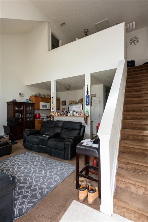 living room with a towering ceiling and carpet