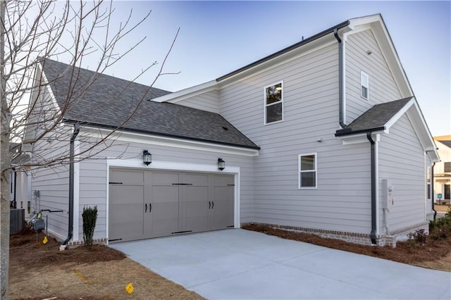 view of home's exterior featuring central air condition unit and a garage