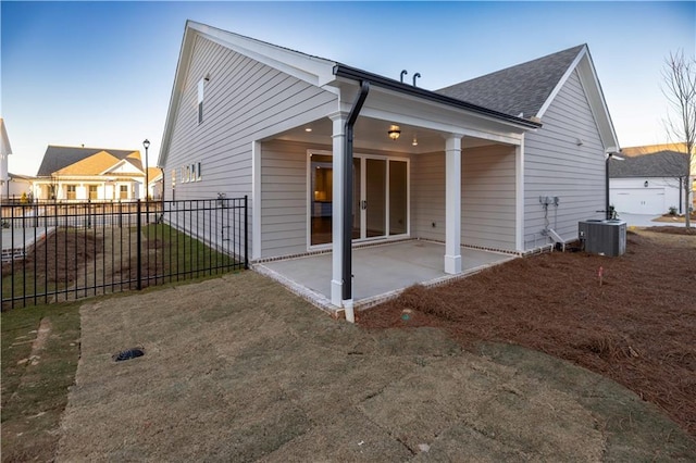 back of property featuring central air condition unit, a yard, and a patio