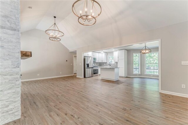 14 Brook Valley Ct SW, Rome, GA 30165 - unfurnished living room featuring a chandelier, light wood-style floors, lofted ceiling, baseboards, and a sink