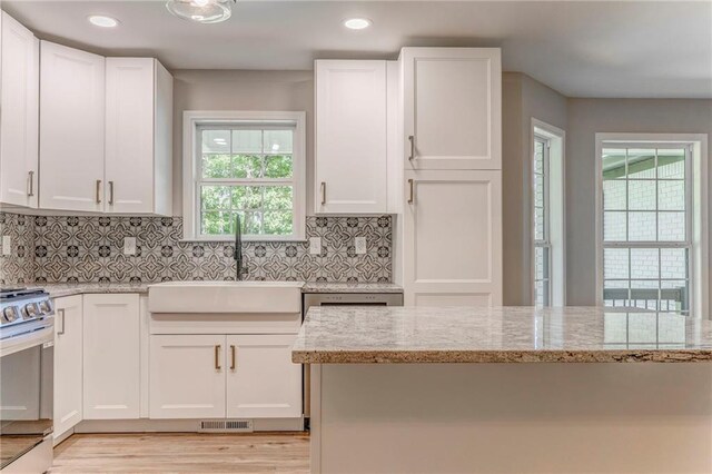 14 Brook Valley Ct SW, Rome, GA 30165 - kitchen with stainless steel appliances, a sink, white cabinets, light stone counters, and tasteful backsplash