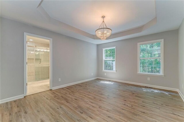 14 Brook Valley Ct SW, Rome, GA 30165 - spare room featuring a tray ceiling, wood finished floors, a chandelier, and baseboards
