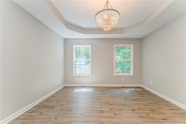 14 Brook Valley Ct SW, Rome, GA 30165 - spare room featuring a raised ceiling, a chandelier, light wood-type flooring, and baseboards