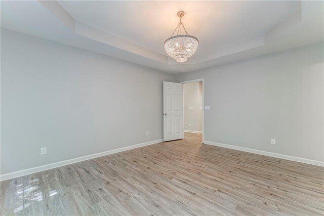 14 Brook Valley Ct SW, Rome, GA 30165 - empty room featuring a chandelier, baseboards, a tray ceiling, and light wood finished floors