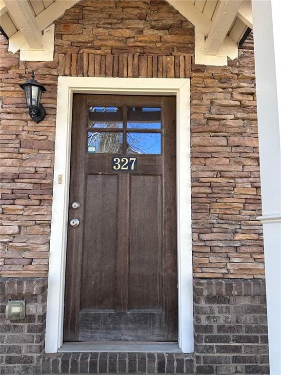 doorway to property with stone siding