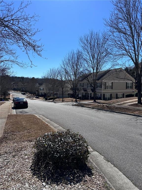 view of street with sidewalks, a residential view, and curbs