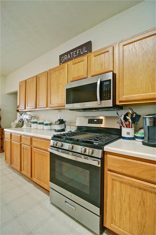 809 Longbranch Ln, Douglasville, GA 30134 - kitchen with appliances with stainless steel finishes, light countertops, a textured ceiling, and light flooring