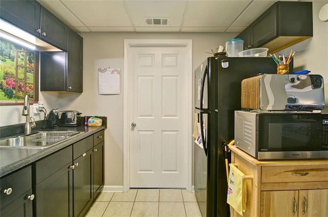 809 Longbranch Ln, Douglasville, GA 30134 - kitchen featuring stainless steel microwave, a sink, light tile patterned floors, freestanding refrigerator, and a paneled ceiling