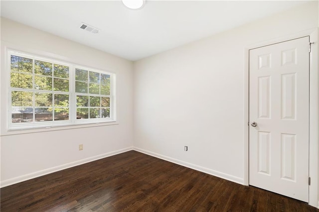 unfurnished room with dark hardwood / wood-style flooring