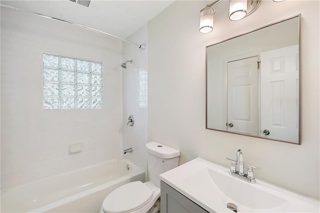 full bathroom featuring vanity, tiled shower / bath combo, and toilet