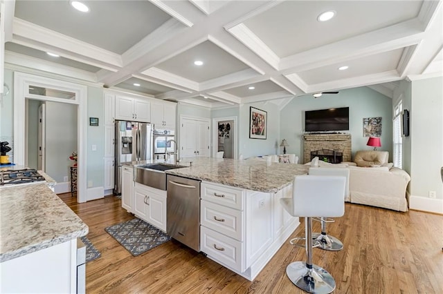 kitchen featuring a large island, white cabinetry, appliances with stainless steel finishes, and light wood-type flooring