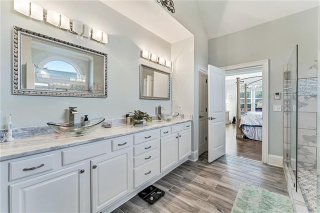 bathroom with vanity, a wealth of natural light, a shower with shower door, and hardwood / wood-style floors