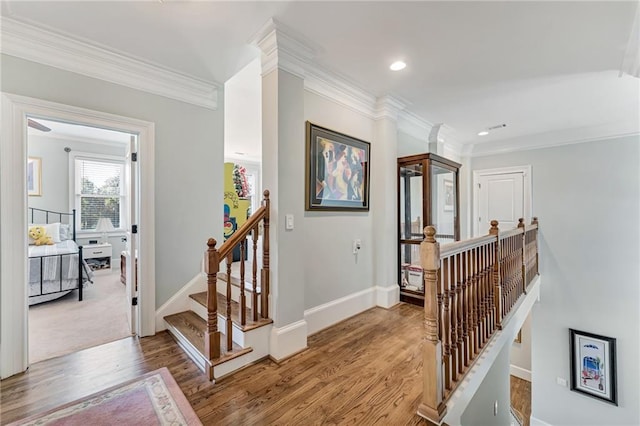 stairs with wood-type flooring and ornamental molding