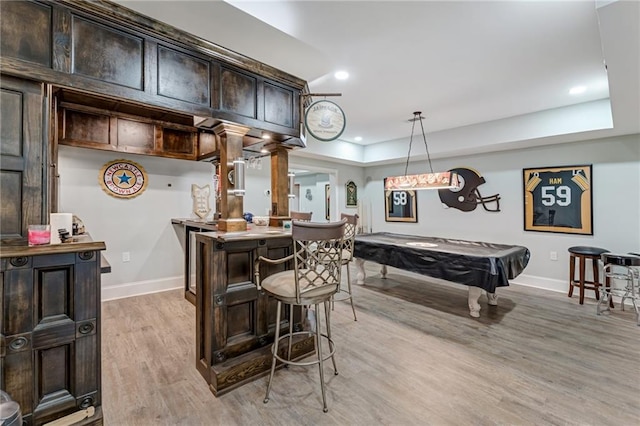 kitchen featuring ornate columns, light hardwood / wood-style flooring, dark brown cabinetry, decorative light fixtures, and billiards