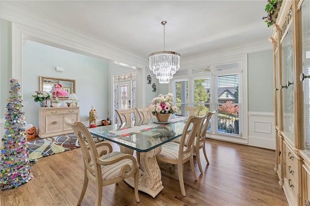 dining area featuring an inviting chandelier, crown molding, and hardwood / wood-style floors