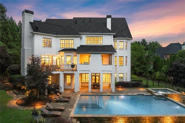 15910 Meadow King Way, Milton, GA 30004 - back of house at dusk featuring a chimney, stairway, a patio, and a pool with connected hot tub