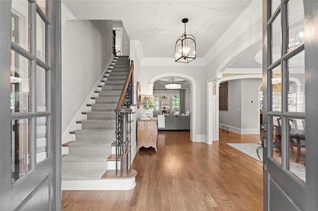 15910 Meadow King Way, Milton, GA 30004 - entrance foyer featuring arched walkways, a chandelier, ornamental molding, stairway, and wood finished floors