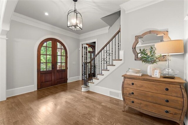 15910 Meadow King Way, Milton, GA 30004 - entrance foyer featuring french doors, wood finished floors, a chandelier, arched walkways, and ornamental molding