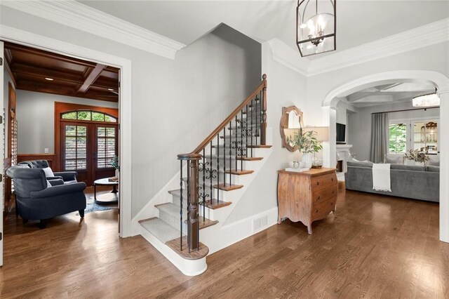15910 Meadow King Way, Milton, GA 30004 - staircase featuring arched walkways, coffered ceiling, ornamental molding, wood finished floors, and a chandelier