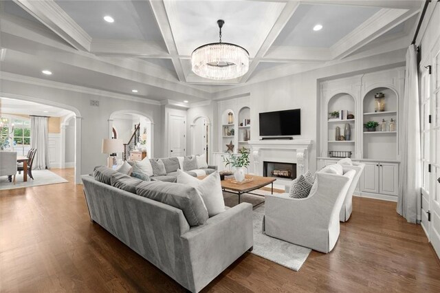 15910 Meadow King Way, Milton, GA 30004 - living room featuring a chandelier, arched walkways, dark wood-style floors, crown molding, and a fireplace