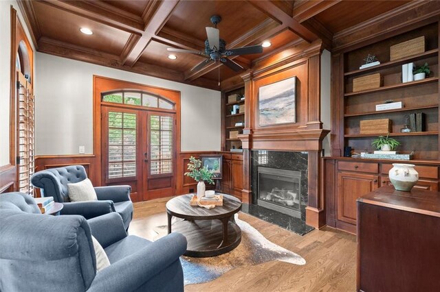 15910 Meadow King Way, Milton, GA 30004 - living area with a wooden ceiling with exposed beams, built in shelves, light wood finished floors, a high end fireplace, and a wainscoted wall