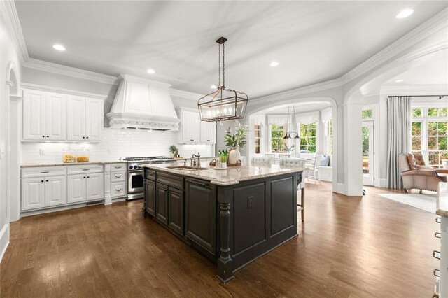 15910 Meadow King Way, Milton, GA 30004 - kitchen featuring stainless steel stove, custom range hood, white cabinets, arched walkways, and recessed lighting