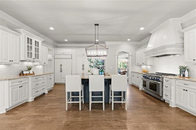 15910 Meadow King Way, Milton, GA 30004 - kitchen with high end appliances, white cabinetry, decorative backsplash, a kitchen breakfast bar, and recessed lighting
