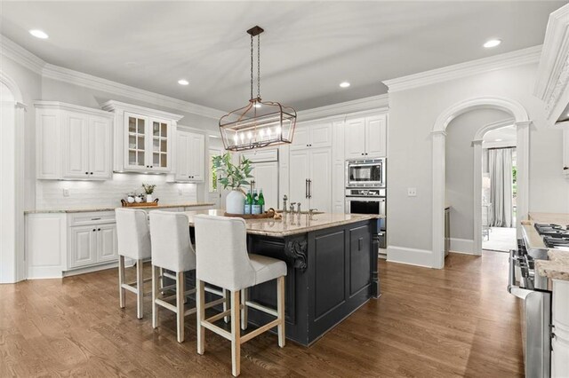 15910 Meadow King Way, Milton, GA 30004 - kitchen featuring stainless steel appliances, arched walkways, white cabinetry, dark wood-style floors, and recessed lighting