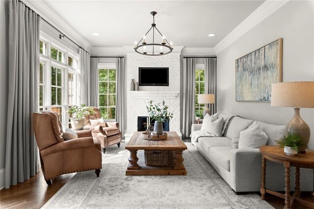 15910 Meadow King Way, Milton, GA 30004 - living room featuring crown molding, healthy amount of natural light, a fireplace, wood finished floors, and a chandelier