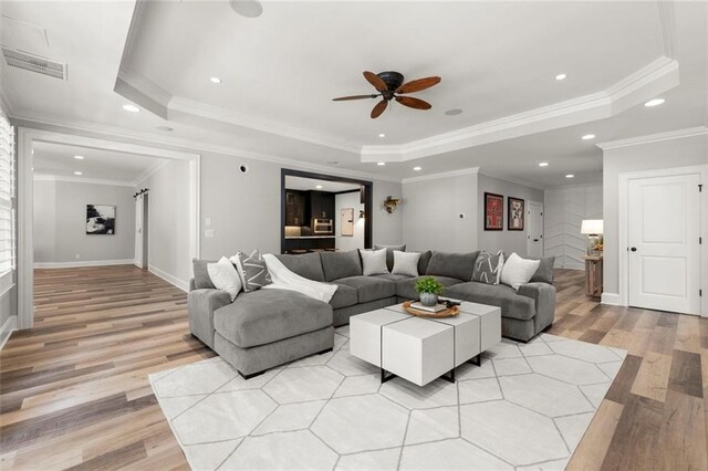 15910 Meadow King Way, Milton, GA 30004 - living area with light wood-style flooring, a tray ceiling, a ceiling fan, ornamental molding, and recessed lighting