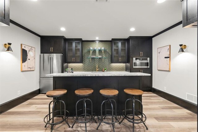 15910 Meadow King Way, Milton, GA 30004 - kitchen featuring appliances with stainless steel finishes, a center island, tasteful backsplash, a kitchen breakfast bar, and ornamental molding