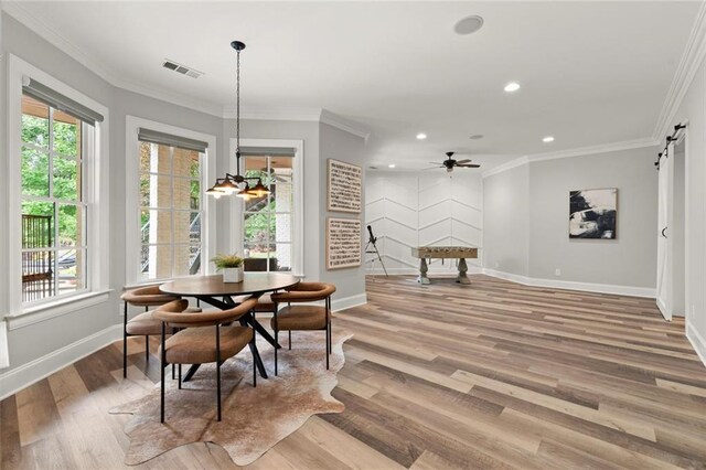 15910 Meadow King Way, Milton, GA 30004 - dining space with light wood finished floors, a barn door, recessed lighting, ornamental molding, and a ceiling fan