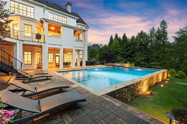 15910 Meadow King Way, Milton, GA 30004 - pool at dusk featuring a patio, a pool with connected hot tub, and a yard