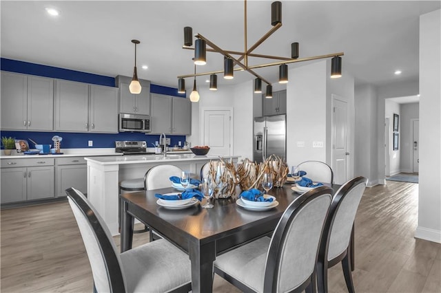dining area with light wood-style flooring, recessed lighting, and baseboards