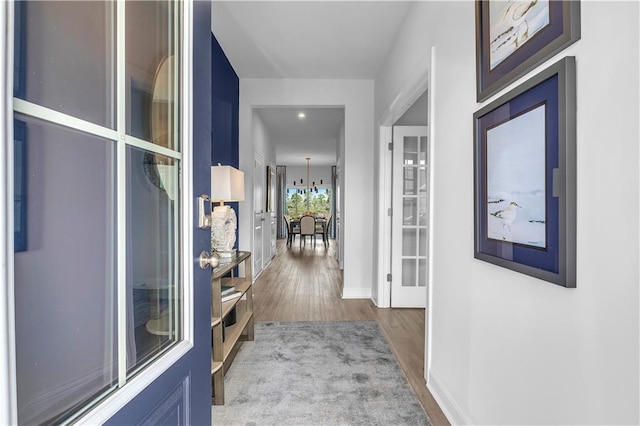 hall featuring wood finished floors and baseboards