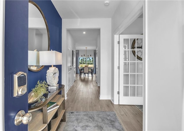 hallway with wood finished floors, baseboards, and recessed lighting