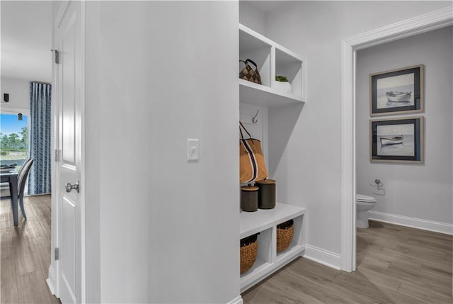 mudroom featuring wood finished floors and baseboards