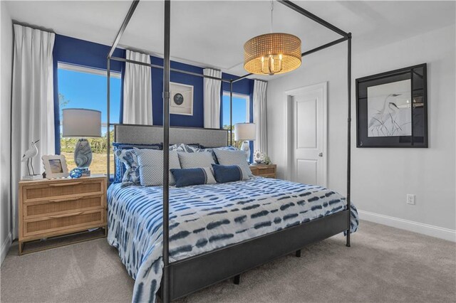 bedroom with carpet, baseboards, and a chandelier