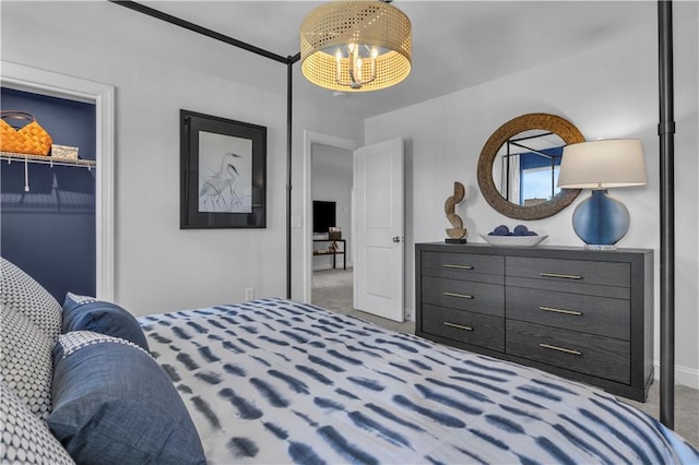 carpeted bedroom featuring a chandelier, baseboards, and a closet