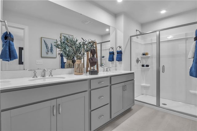 bathroom featuring a stall shower, double vanity, and recessed lighting