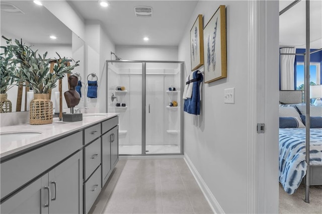 ensuite bathroom featuring baseboards, a shower stall, double vanity, recessed lighting, and tile patterned floors