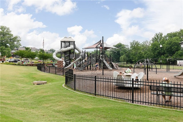 community jungle gym with a yard and fence