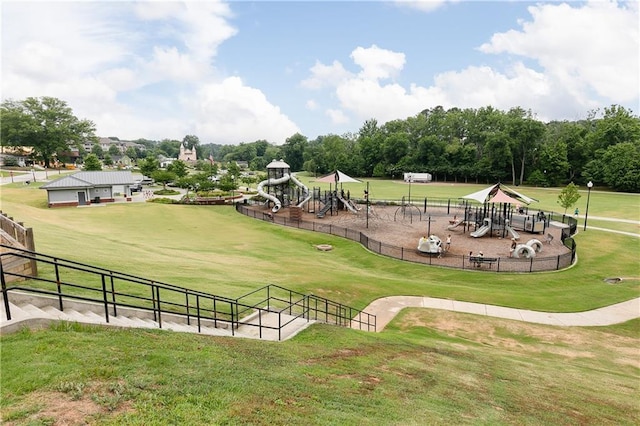 exterior space featuring playground community, a yard, and fence