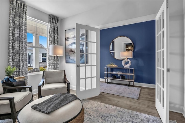 sitting room with french doors, baseboards, and wood finished floors