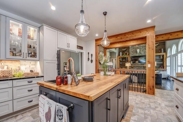 kitchen with gray cabinets, wooden counters, hanging light fixtures, a center island, and stainless steel fridge with ice dispenser